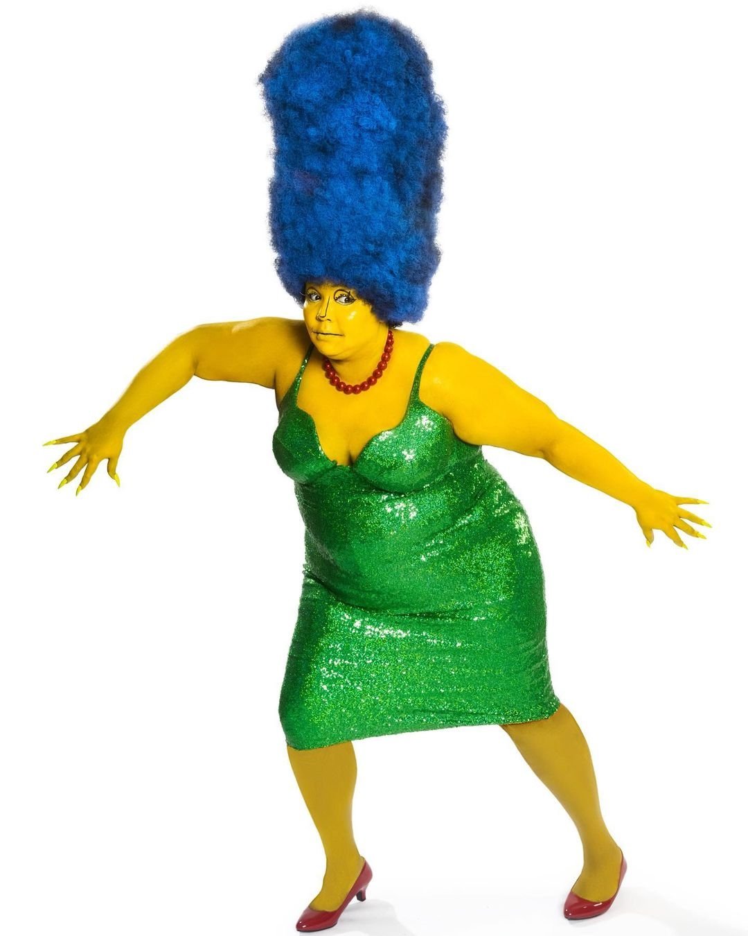 Pessoa usando fantasia feminina de Halloween inspirada em uma personagem, com vestido verde brilhante e peruca azul alta.