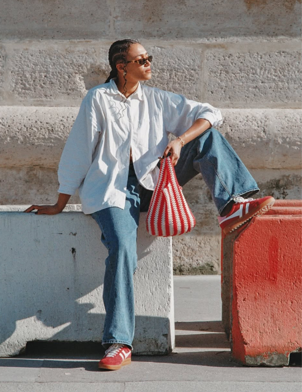Neste look moderno, a combinação de um tênis vermelho com calça jeans ampla e camisa oversized branca cria um visual casual e estiloso. O look mostra como usar tênis vermelho de forma fácil.