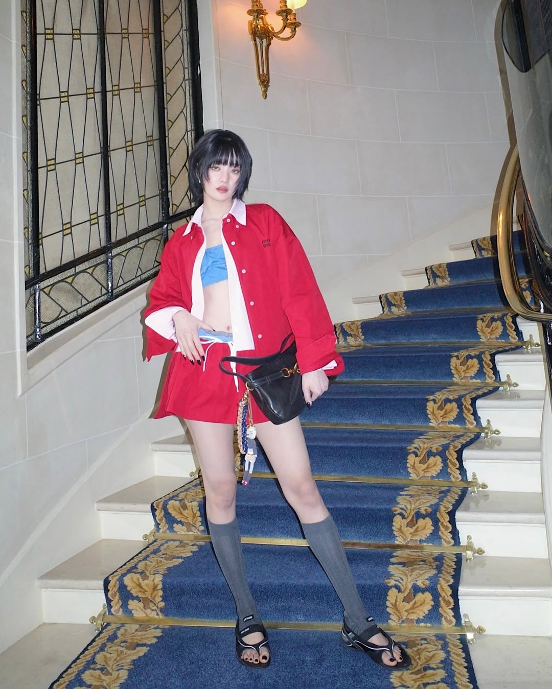 Pessoa em roupa vermelha estilosa com vibe de surf urbano, em escadaria elegante.