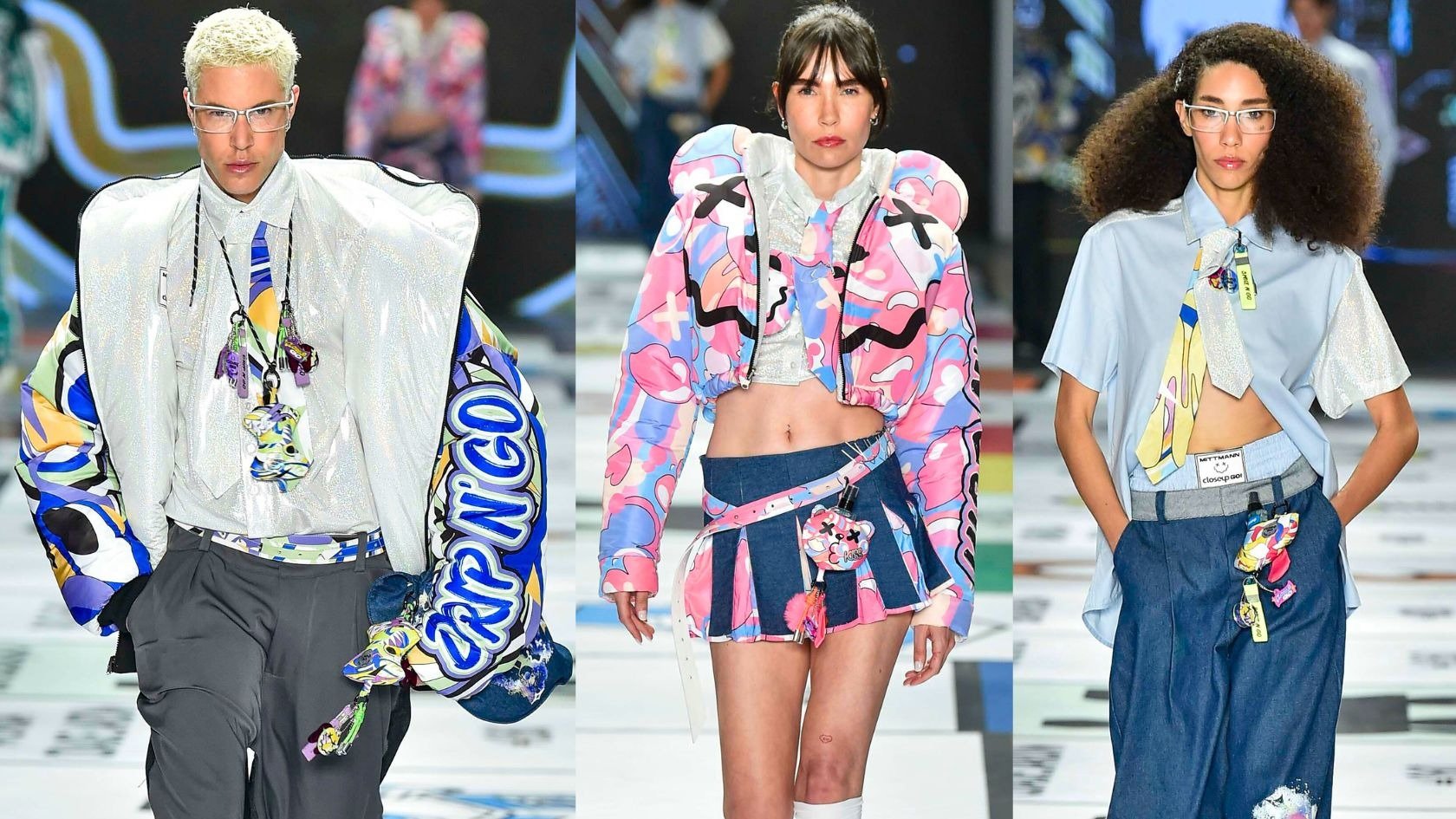 No desfile, modelos exibem looks modernos, destacando o uso de chaveiros estilosos como acessórios.