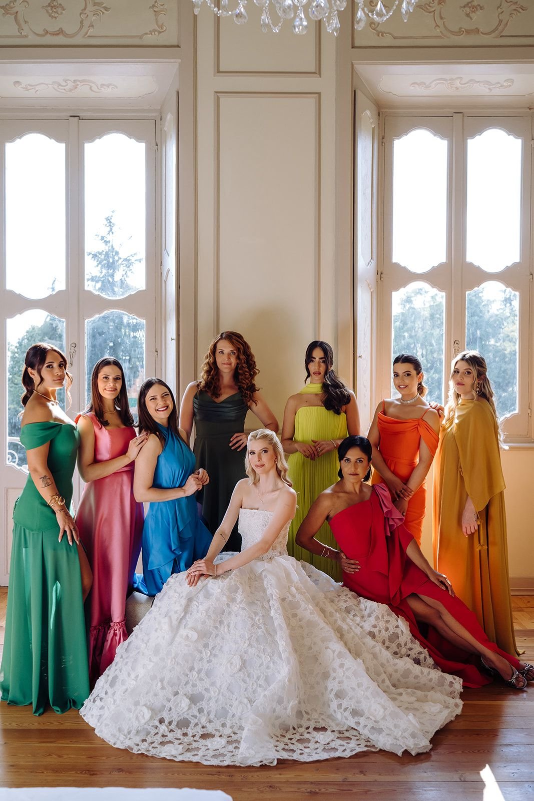 Desfile de moda com foco em vestidos de casamento e convidados em cores vibrantes.