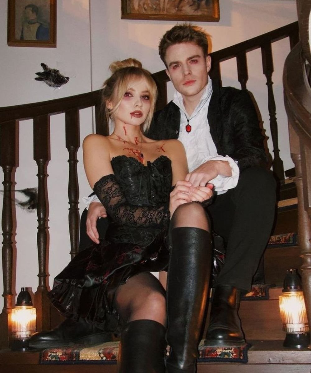 Casal usando fantasia de vampiro para Halloween 2025 exibe um visual impactante.