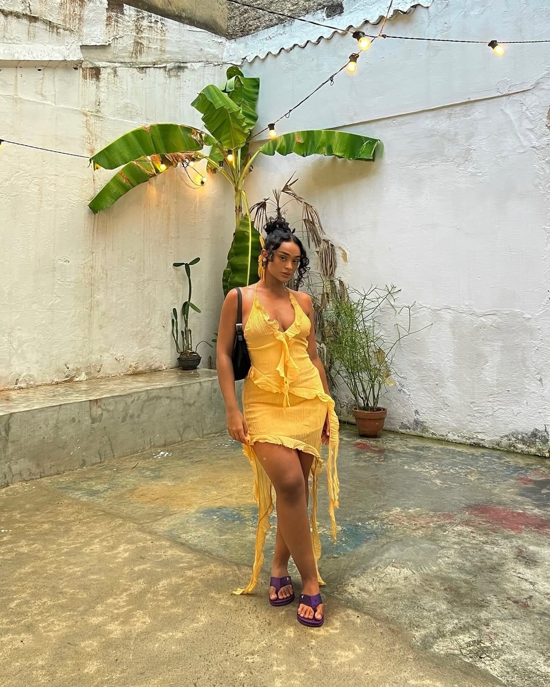 Mulher com look para barzinho à noite com um vestido amarelo vibrante, que destaca a silhueta e traz um toque de frescor.