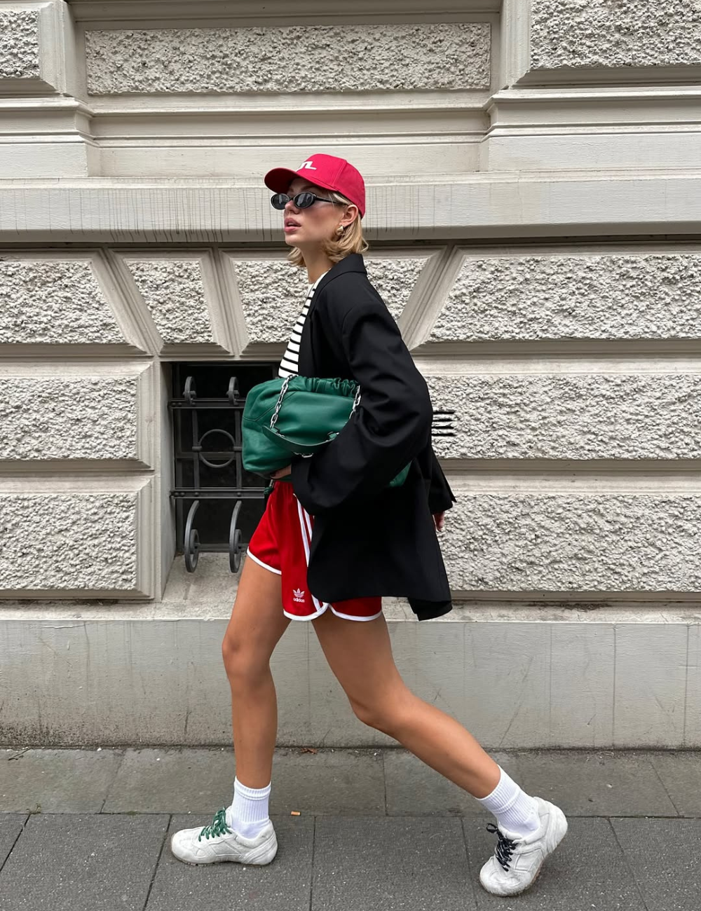 O look apresenta uma combinação despojada e estilosa, ideal para quem busca looks bonitos e fáceis. A modelo usa uma camiseta listrada sob um blazer preto, que confere sofisticação ao visual. Ideias de looks bonitos e fáceis.