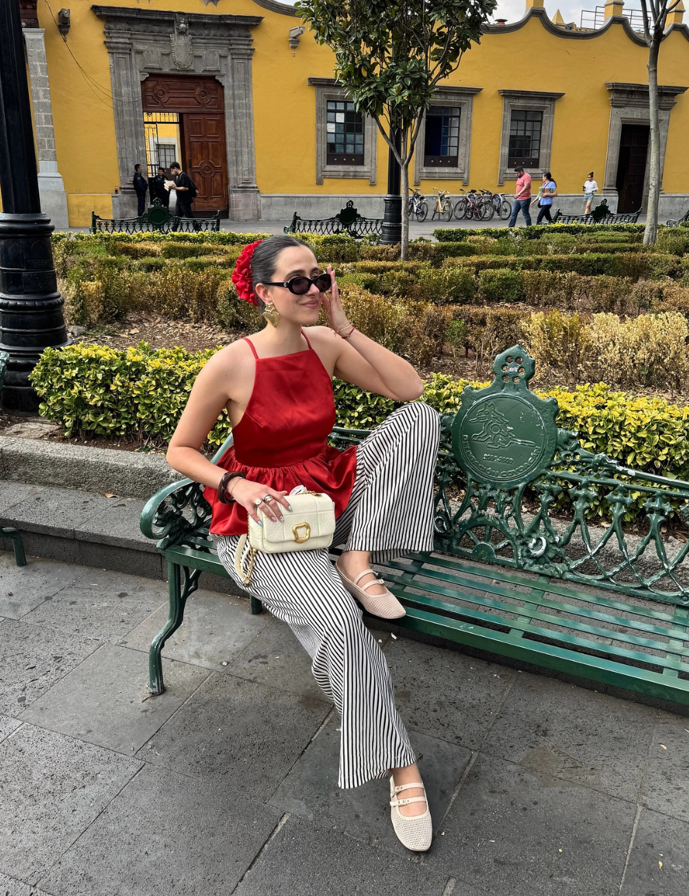 Pessoa sentada em um banco usando um dos looks com blusas frescas.