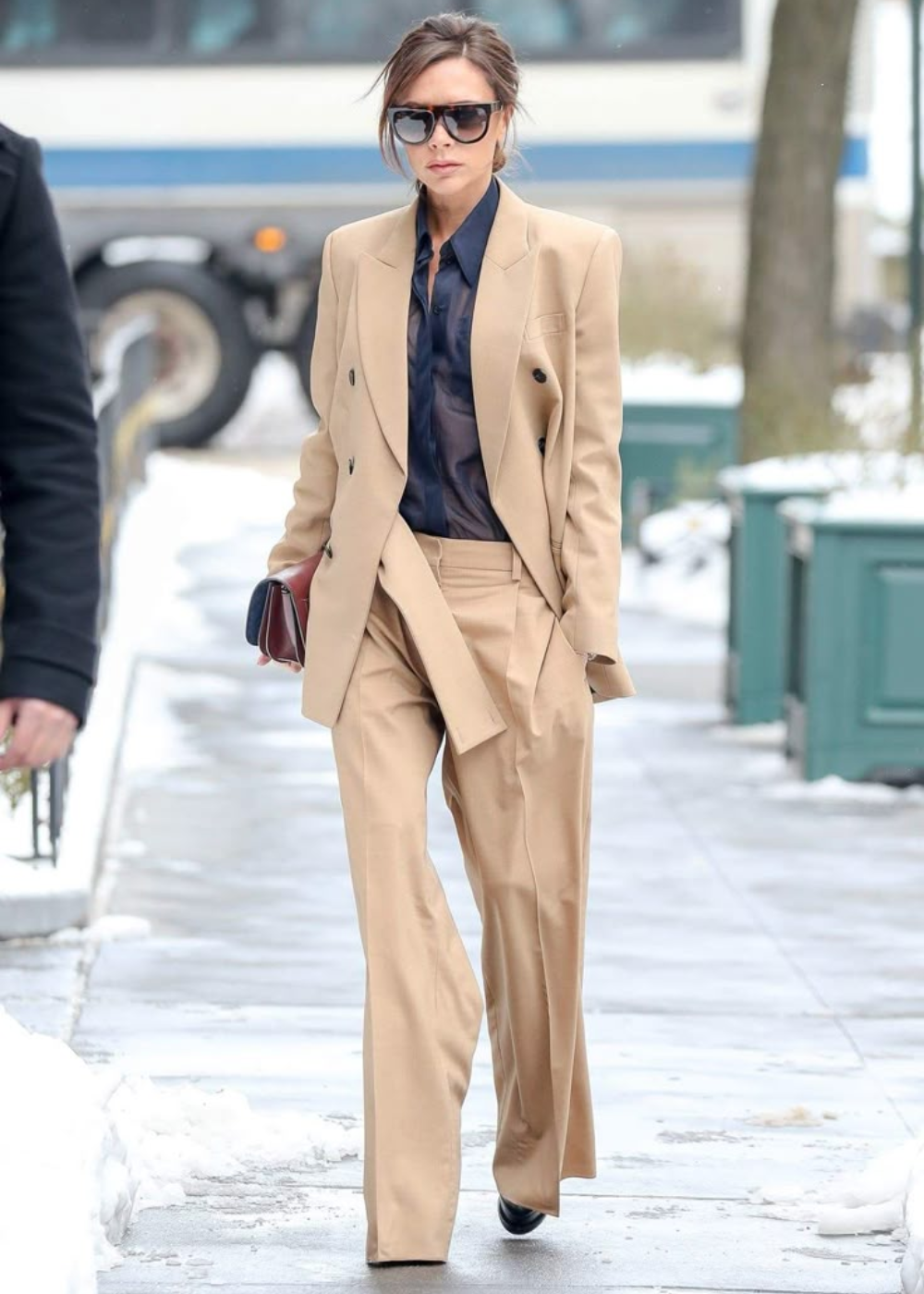 O look com terninho apresenta um conjunto em tom bege claro, com blazer oversized e calça de corte reto, que transmite elegância e sofisticação. A blusa preta transparente adiciona um toque moderno e ousado.