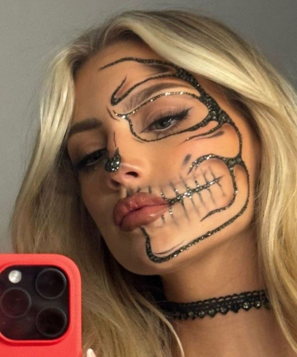 Mulher com maquiagem de Halloween fácil exibe um visual impactante, combinando traços de esqueleto com brilho.