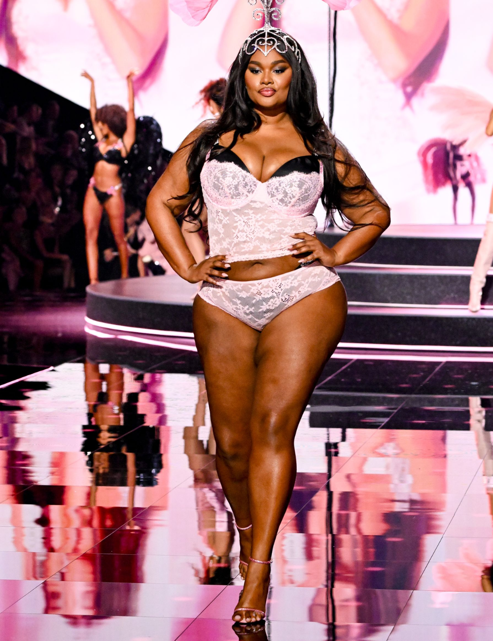 Desfile de moda com modelo usando lingerie rosa e maquiagem glow, destacando a pele.