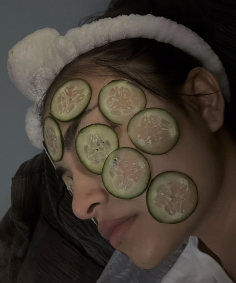 Rodelas de pepino sobre o rosto de uma pessoa deitada, destacando benefícios do pepino na pele.