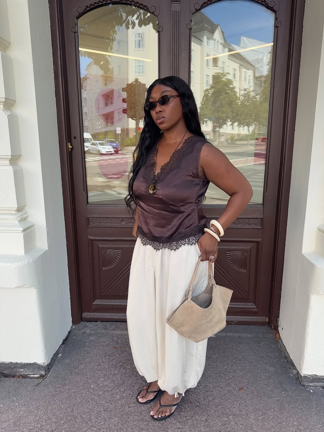 A imagem apresenta uma mulher usando uma blusa de seda marrom com detalhes em renda, ideal para os modelos de blusa para verão. Modelos de blusa para verão