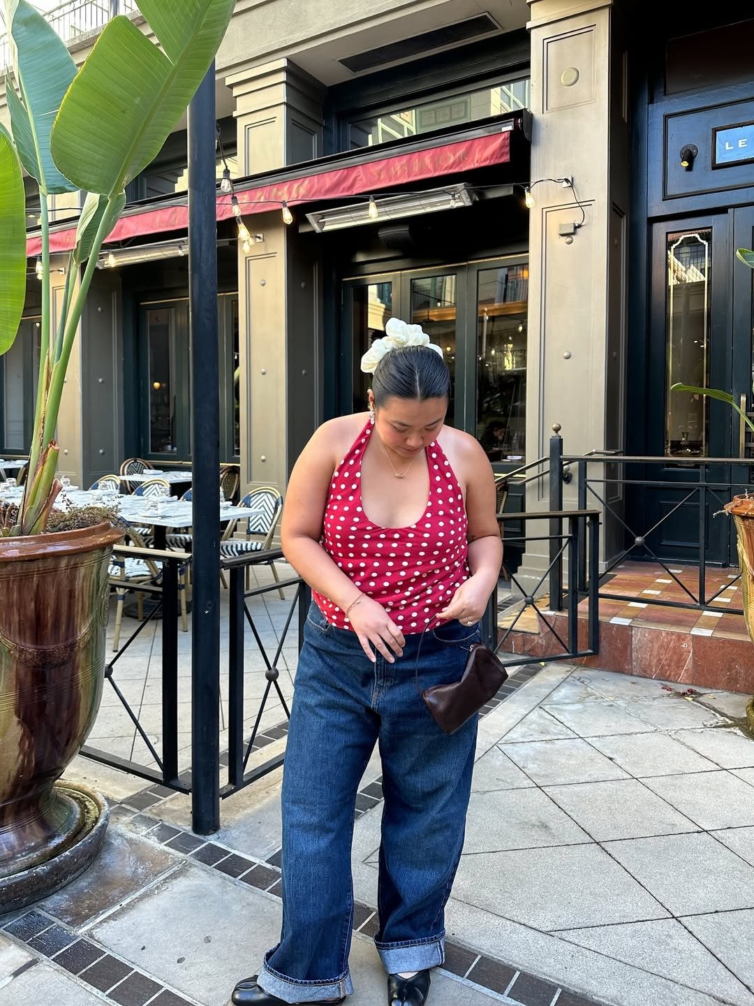 A imagem apresenta uma mulher usando uma blusa de alças com estampa de bolinhas brancas em fundo vermelho, ideal para os modelos de blusa para verão. Modelos de blusa para verão