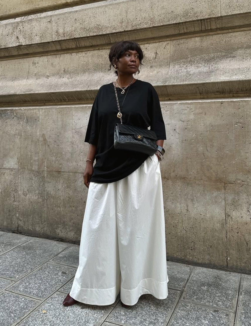 Modelos de saia da moda incluem opções amplas e elegantes, como a apresentada na imagem. A peça branca, com caimento fluido, destaca-se pela sua versatilidade e conforto, ideal para diferentes ocasiões.