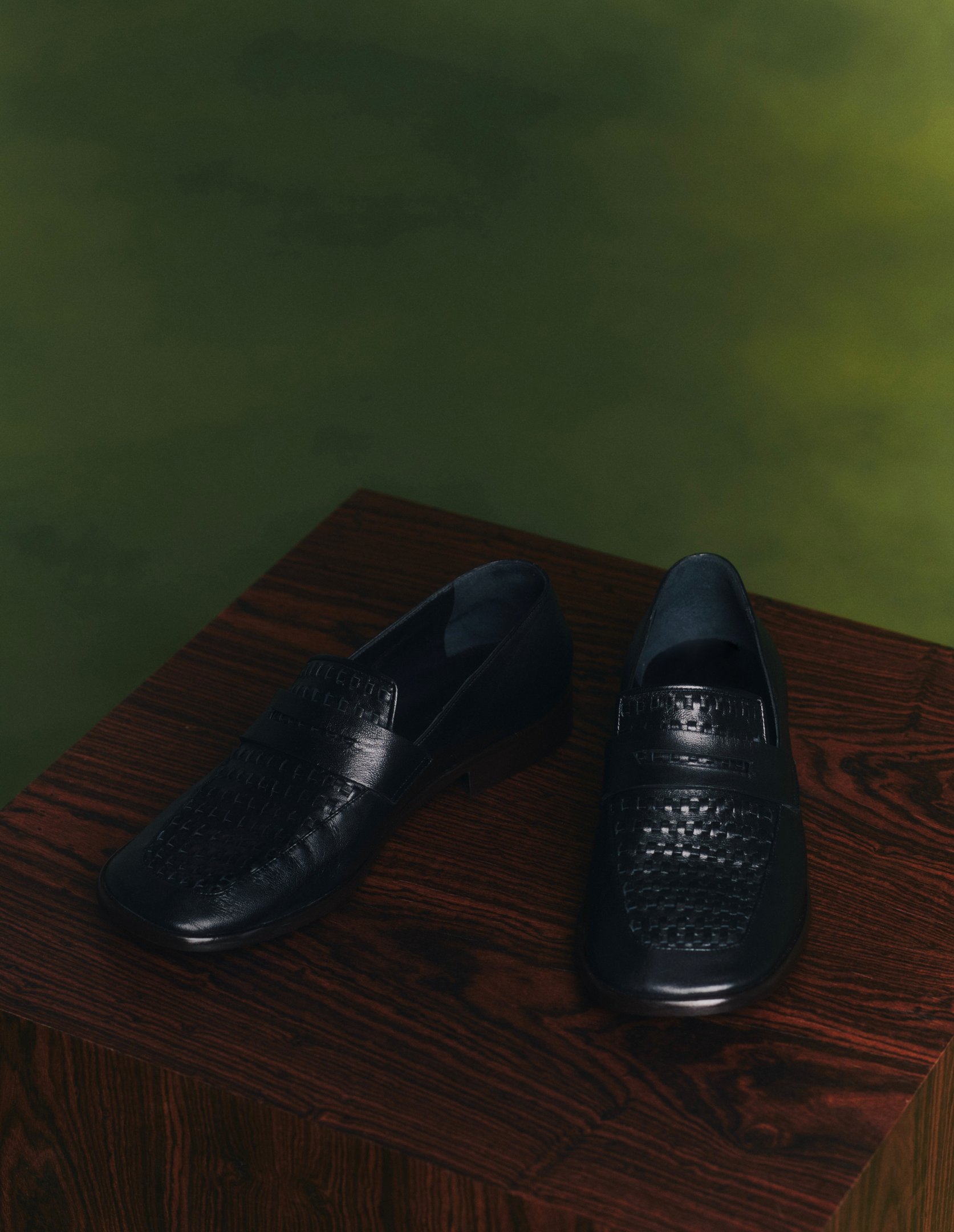 Os sapatos da coleção Mondepars apresentam um design sofisticado em couro preto, com detalhes em textura trançada que conferem elegância. A sola robusta garante conforto e durabilidade, ideal para diversas ocasiões. A base de madeira escura destaca ainda 