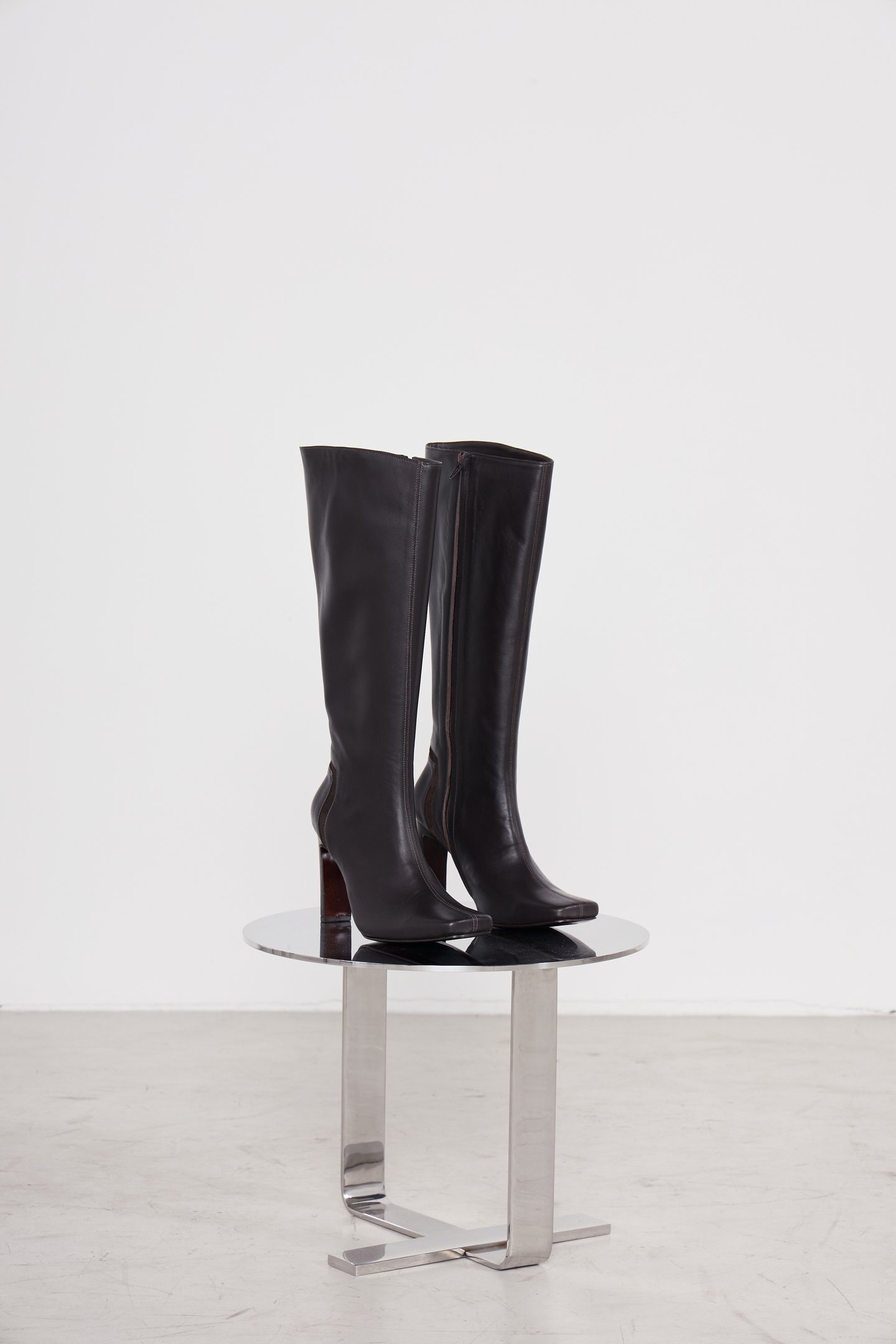 As botas de couro da Mondepars, com cano alto e salto robusto, destacam-se pelo design elegante e moderno. O tom escuro do couro confere sofisticação, ideal para compor looks de inverno. A base em metal reflete a luz, criando um visual contemporâneo. Perf