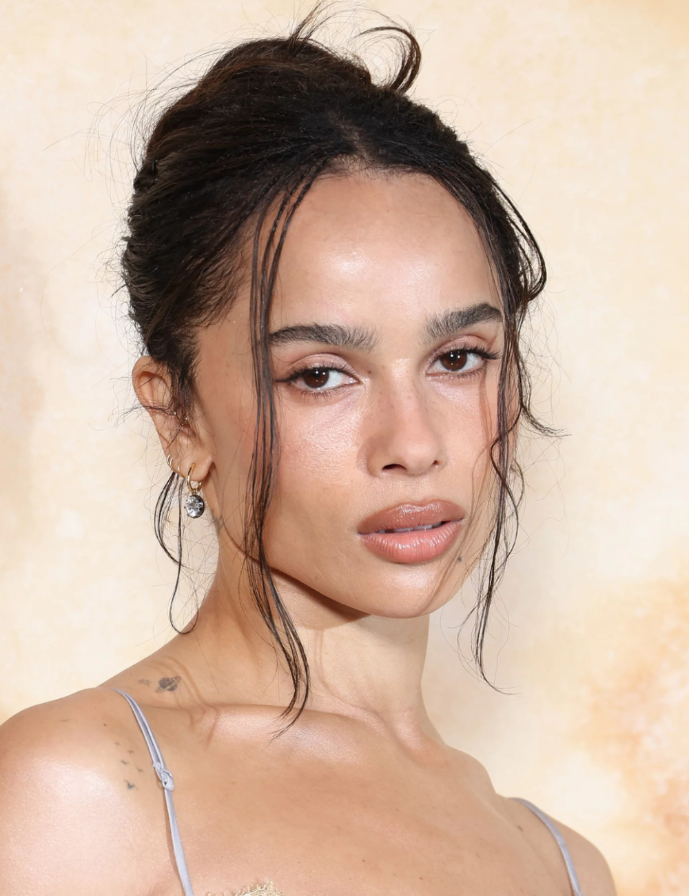 Com um coque elegante e despojado, a imagem mostra uma das ideias de penteados com coque. Fios soltos emolduram o rosto, trazendo leveza ao visual.