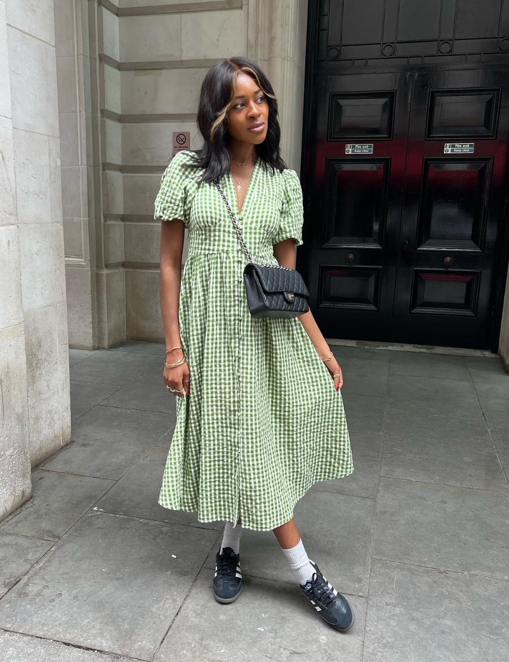 Vestido xadrez verde combinado com tênis azul escuro e bolsa preta a tiracolo. tênis para usar com vestido.