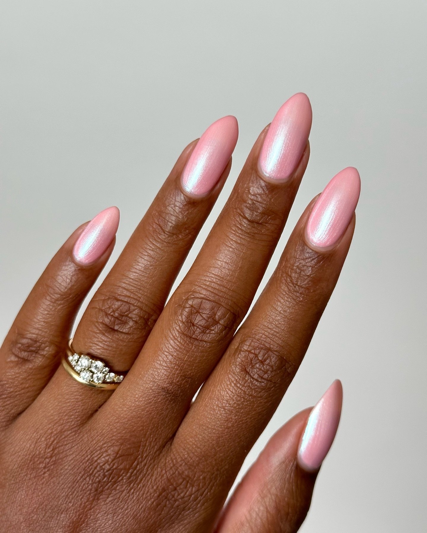 Unhas claras e delicadas pintadas com esmalte rosa metálico.