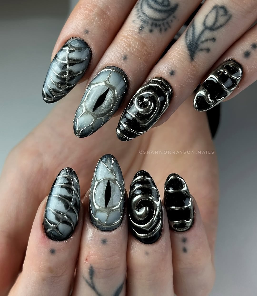 As unhas de Halloween exibem um design ousado e artístico, com uma combinação de tons de preto e cinza.