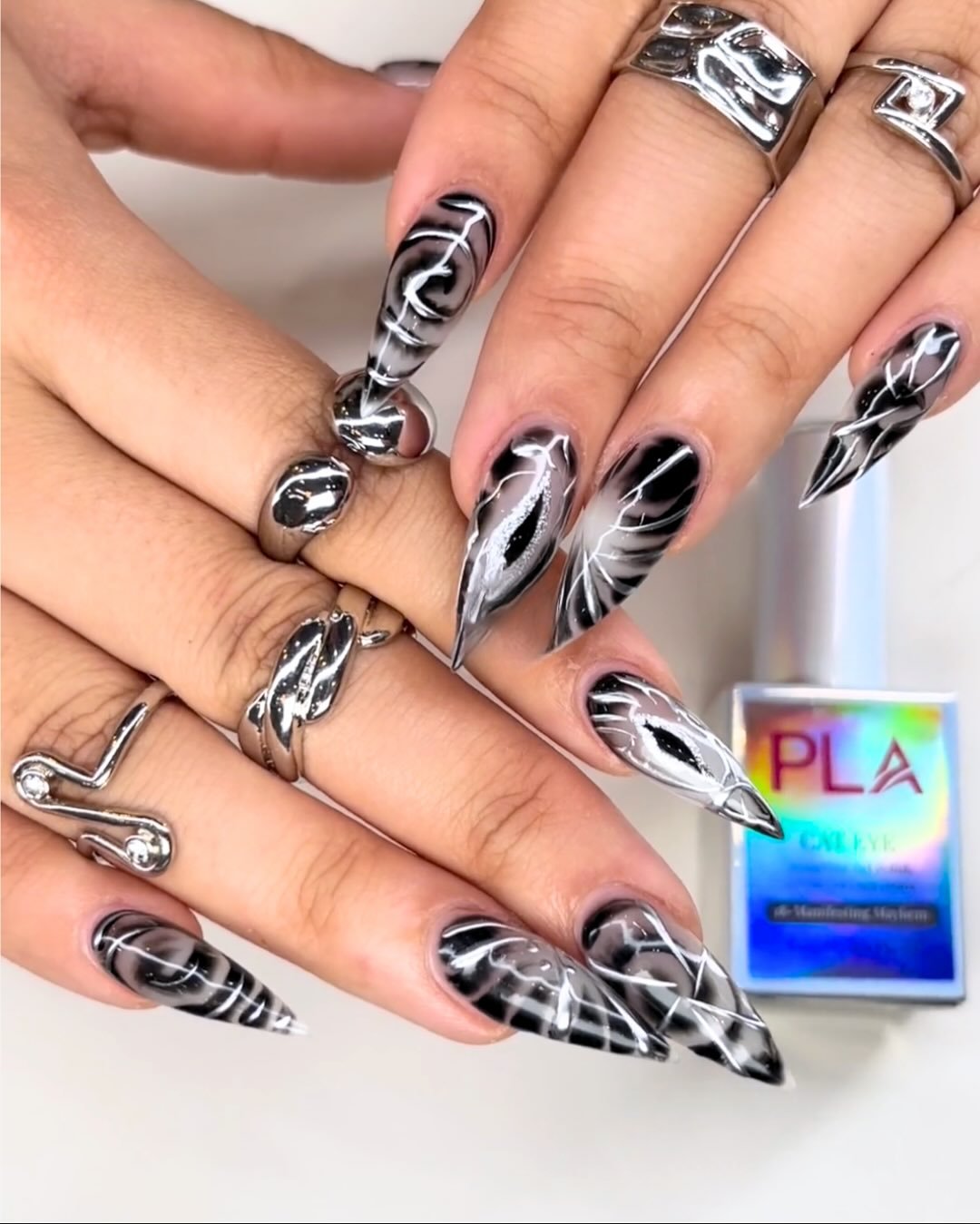 As unhas de Halloween apresentam um design ousado com formato stiletto e esmalte preto como base.