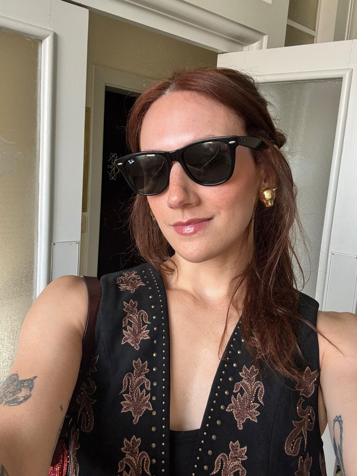 A imagem mostra uma mulher com cabelos castanhos e óculos escuros, destacando um brilho sutil nos lábios, evidenciando o uso do Lip Oil Epidrat Hyalu, um lip oil hidratante e com proteção solar