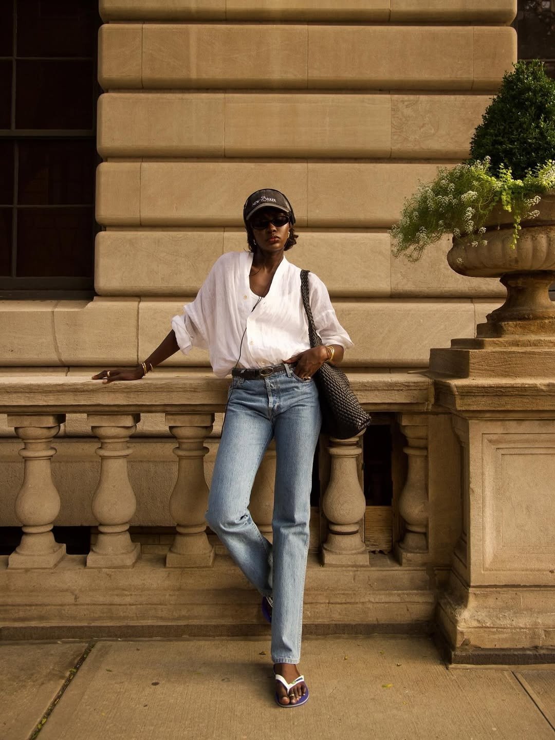 O chinelo azul destaca-se como um acessório versátil e moderno, complementando o look casual. A combinação com uma camisa branca oversized e jeans cria um visual equilibrado e estiloso.