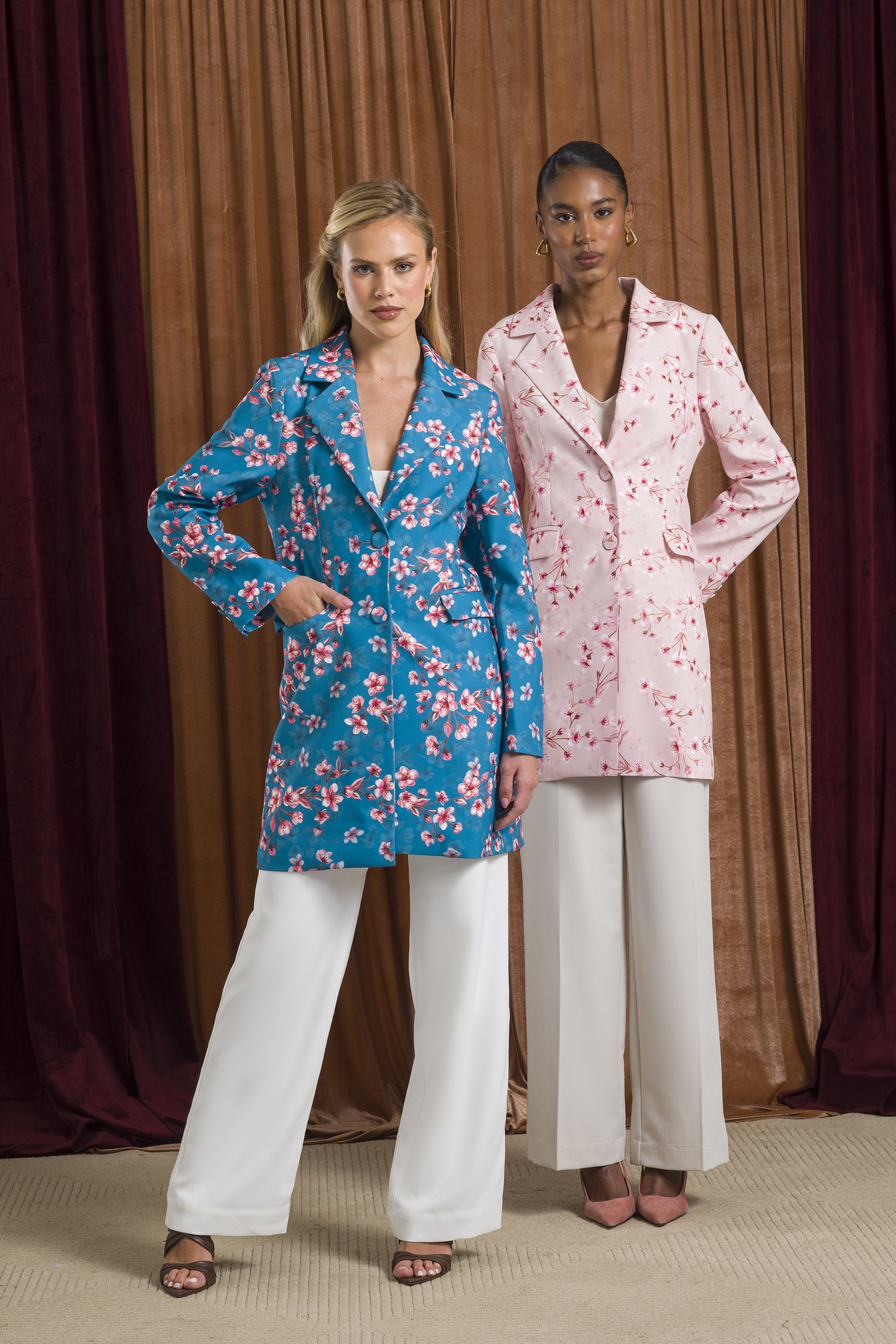 Dra. Cherie apresenta casacos longos florais em azul e rosa com modelagem estruturada, combinados a calças brancas amplas,