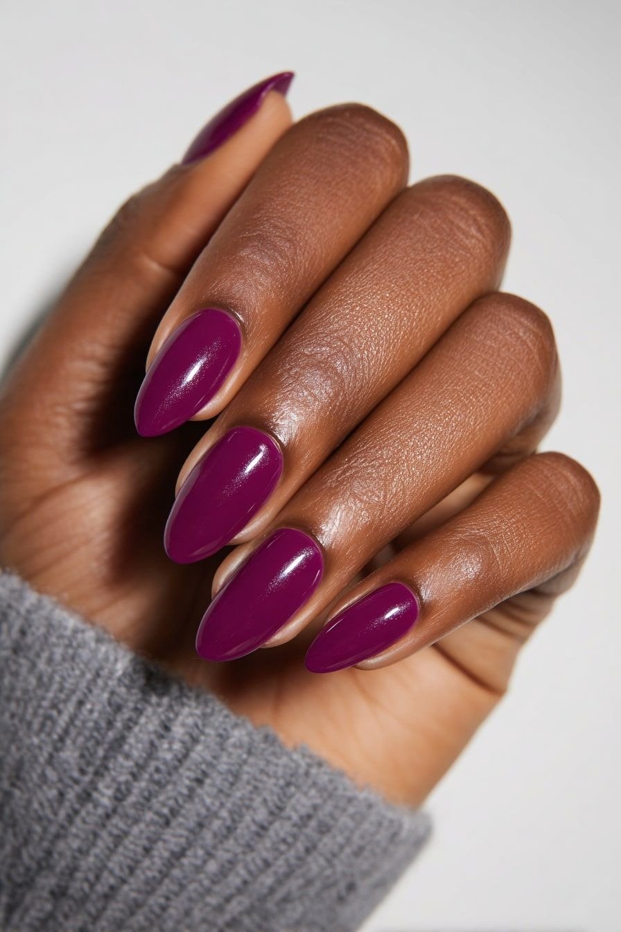 Cores de esmalte 2026 ganham destaque com tom vinho intenso em unhas longas e pontiagudas, combinando com suéter cinza para