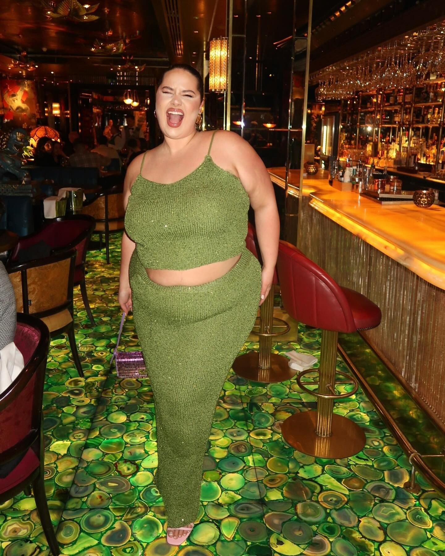 Look natal verde com conjunto de tricô brilhante, top cropped e saia reta, transmitindo alegria e confiança em ambiente