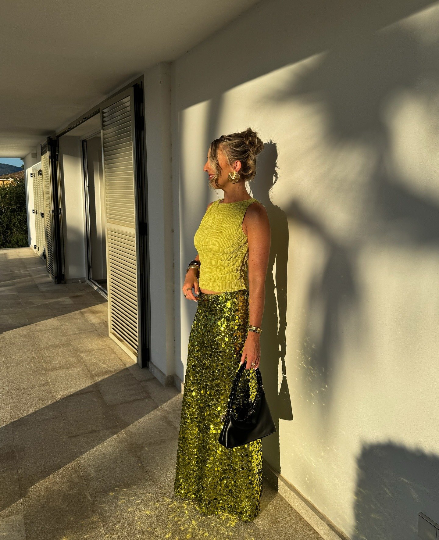 Look natal verde com blusa texturizada sem mangas e saia longa de paetês que refletem luz, transmitindo elegância e brilho