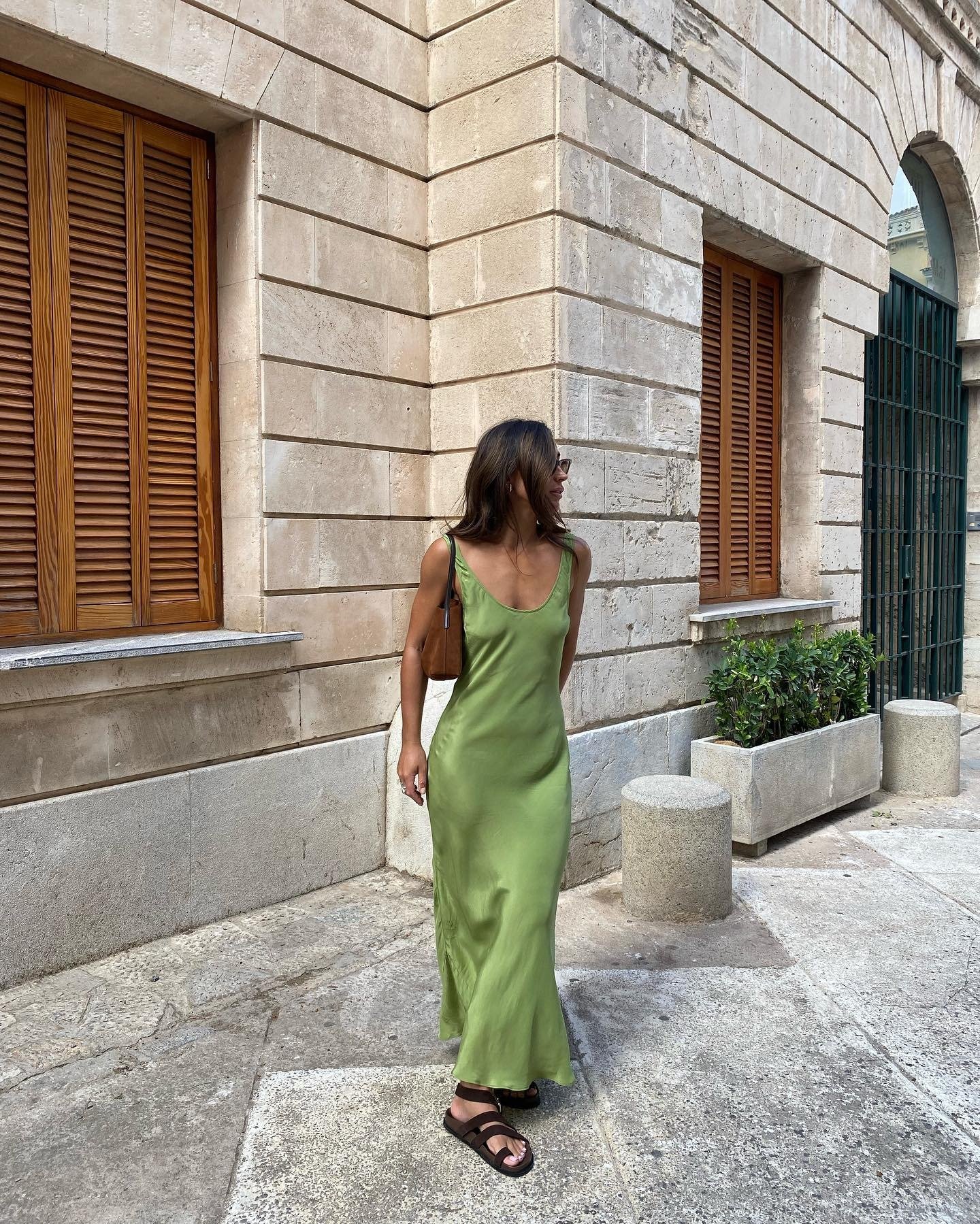 Look natal verde com vestido longo de tecido fluido, modelagem simples e alças finas, transmitindo leveza e elegância casual.