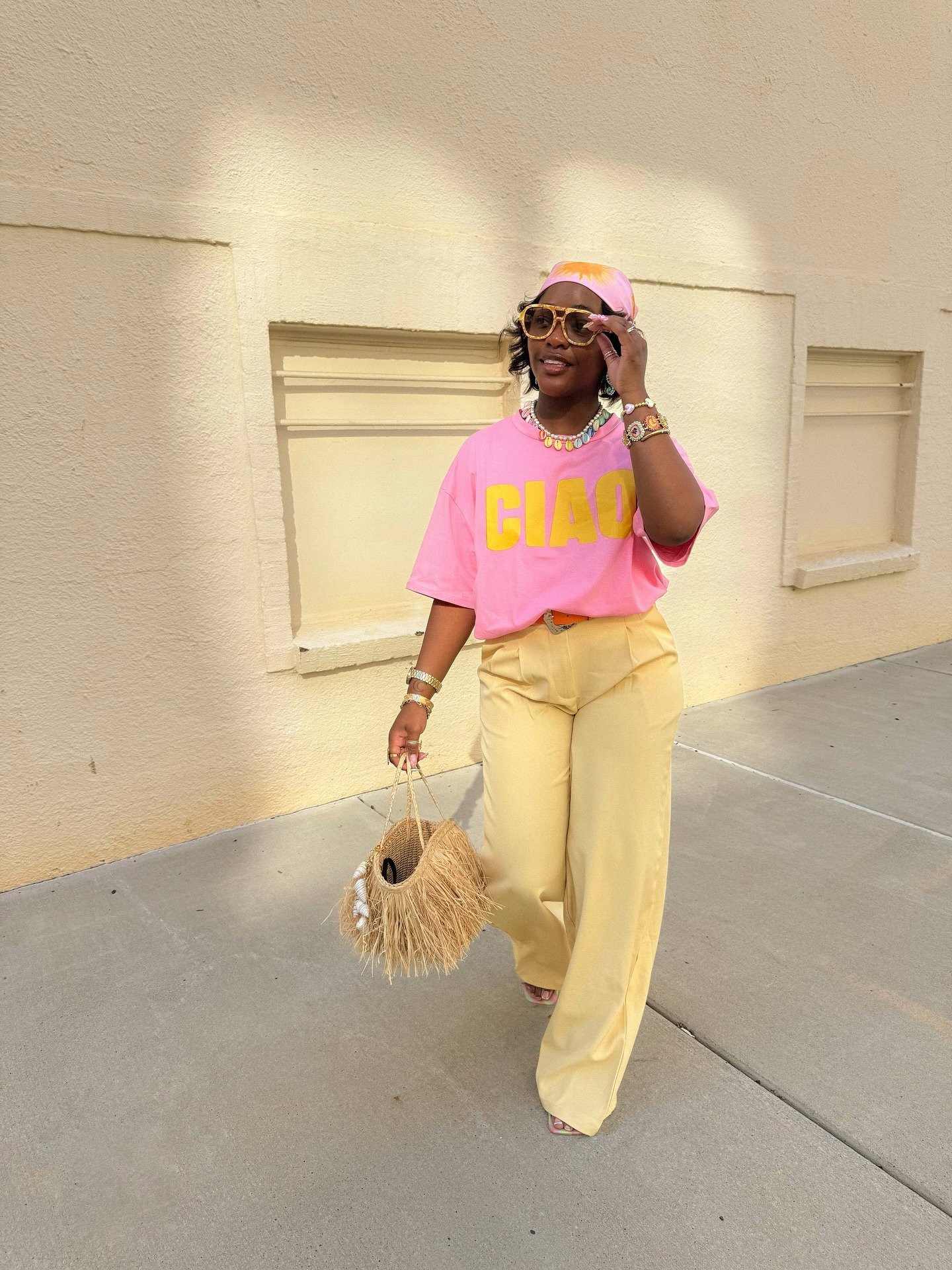 Look rosa com camiseta oversized em algodão rosa vibrante e estampa amarela, combinada a calça ampla amarela.