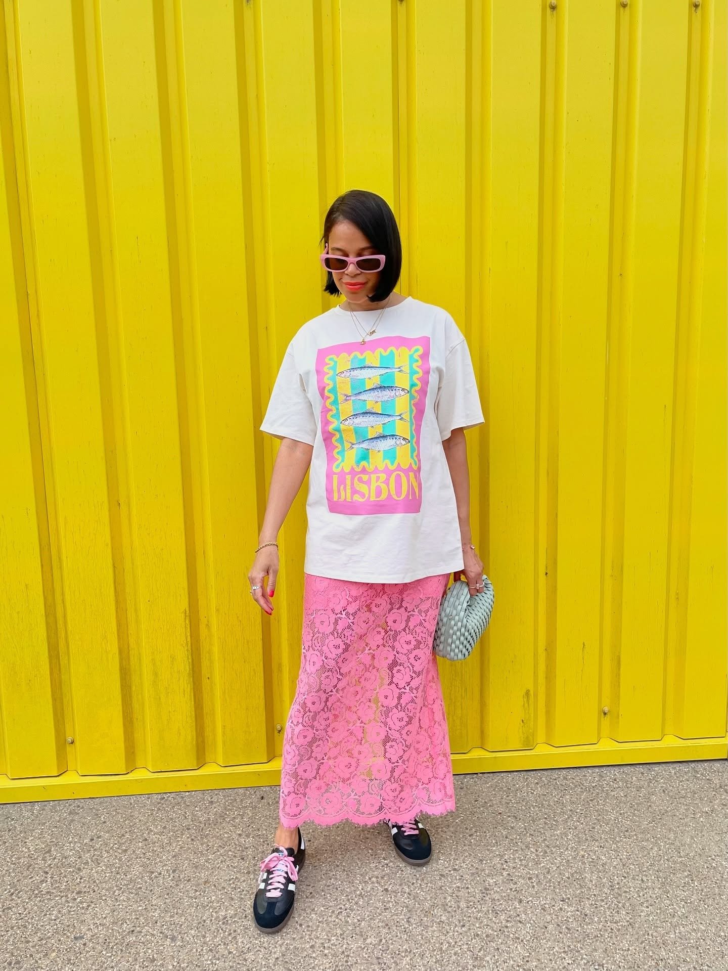 Look rosa combina saia midi de renda delicada com camiseta branca estampada oversized, acessórios modernos.