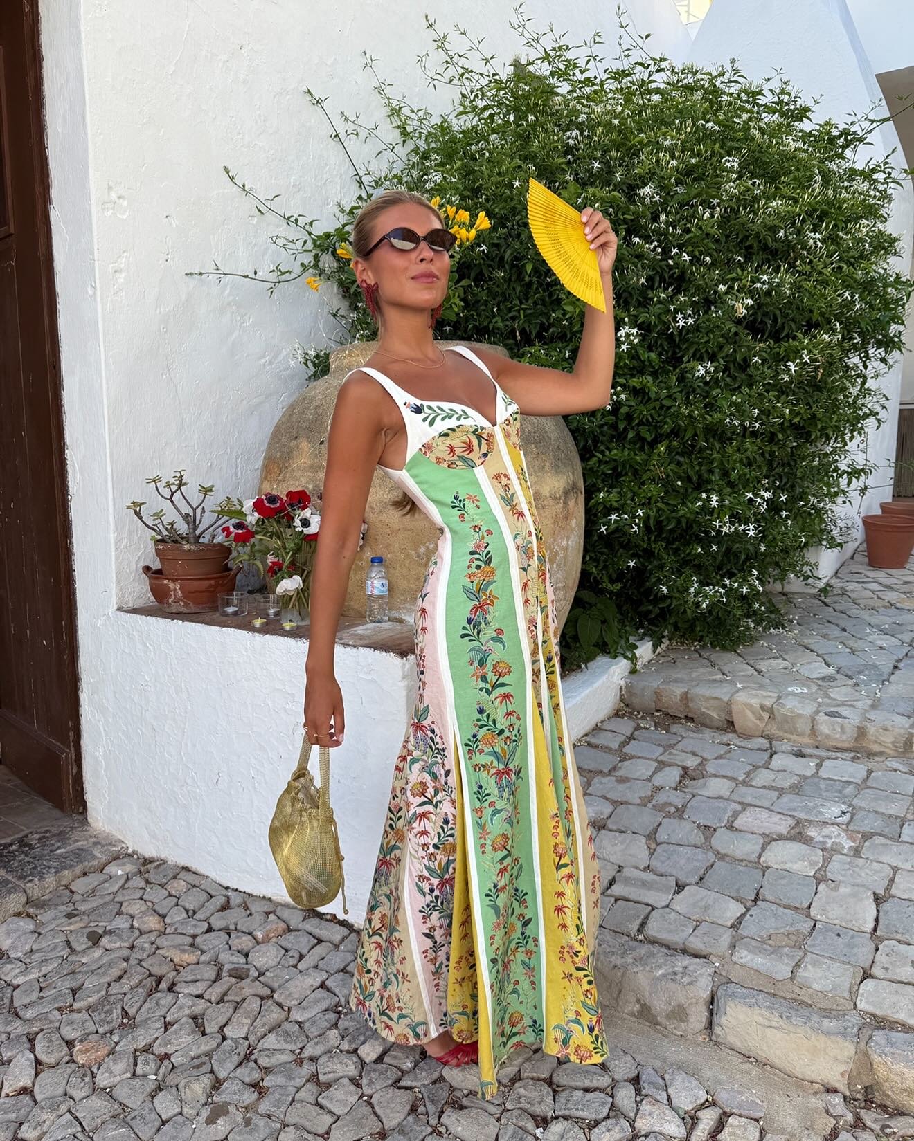 Modelo posa com vestido tendência longo em patchwork floral colorido, tecido leve e decote estruturado, em clima sofisticado