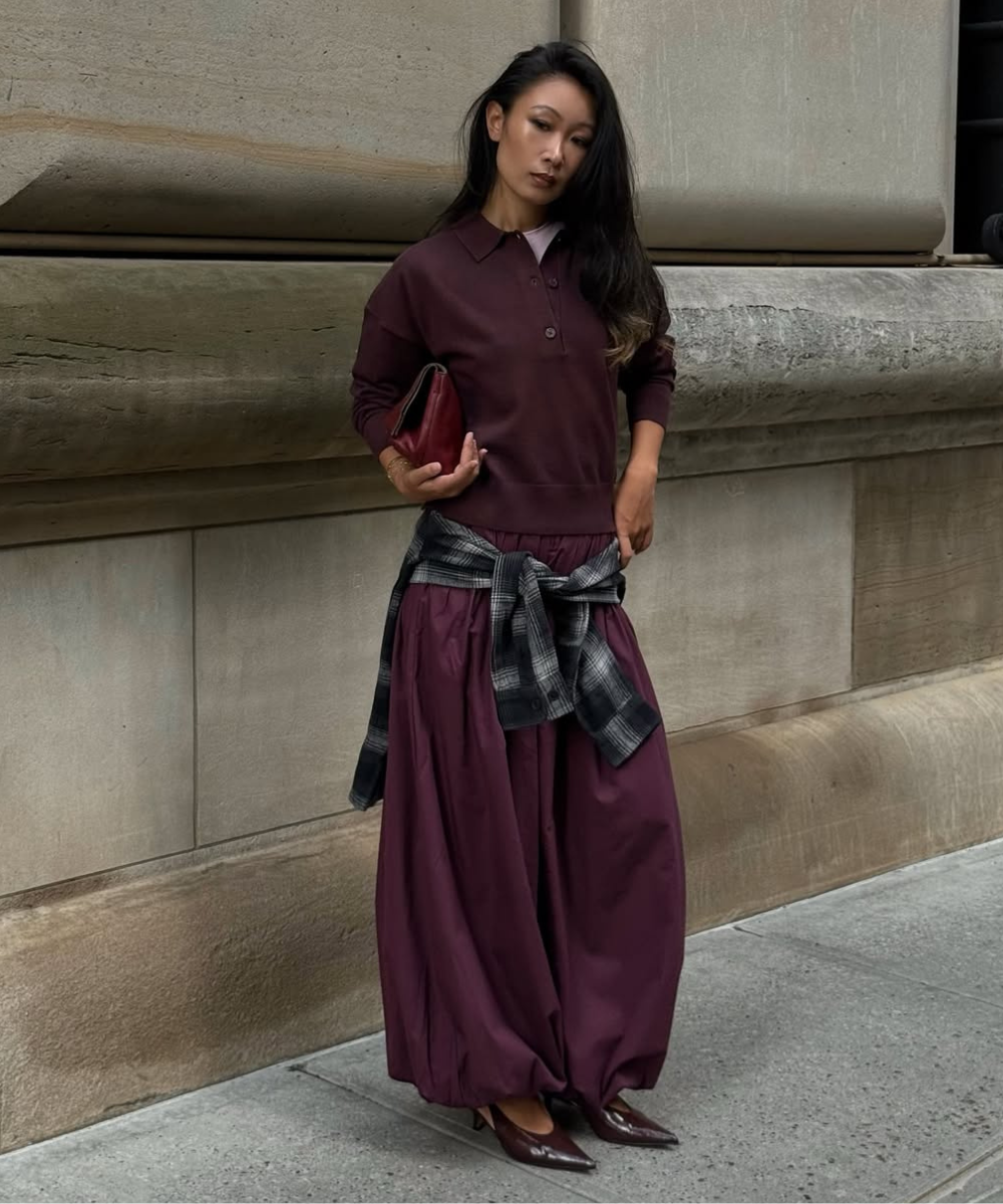 Look com calça balonê vinho em tecido fluido, blusa polo combinando, camisa xadrez amarrada na cintura e scarpin elegante,