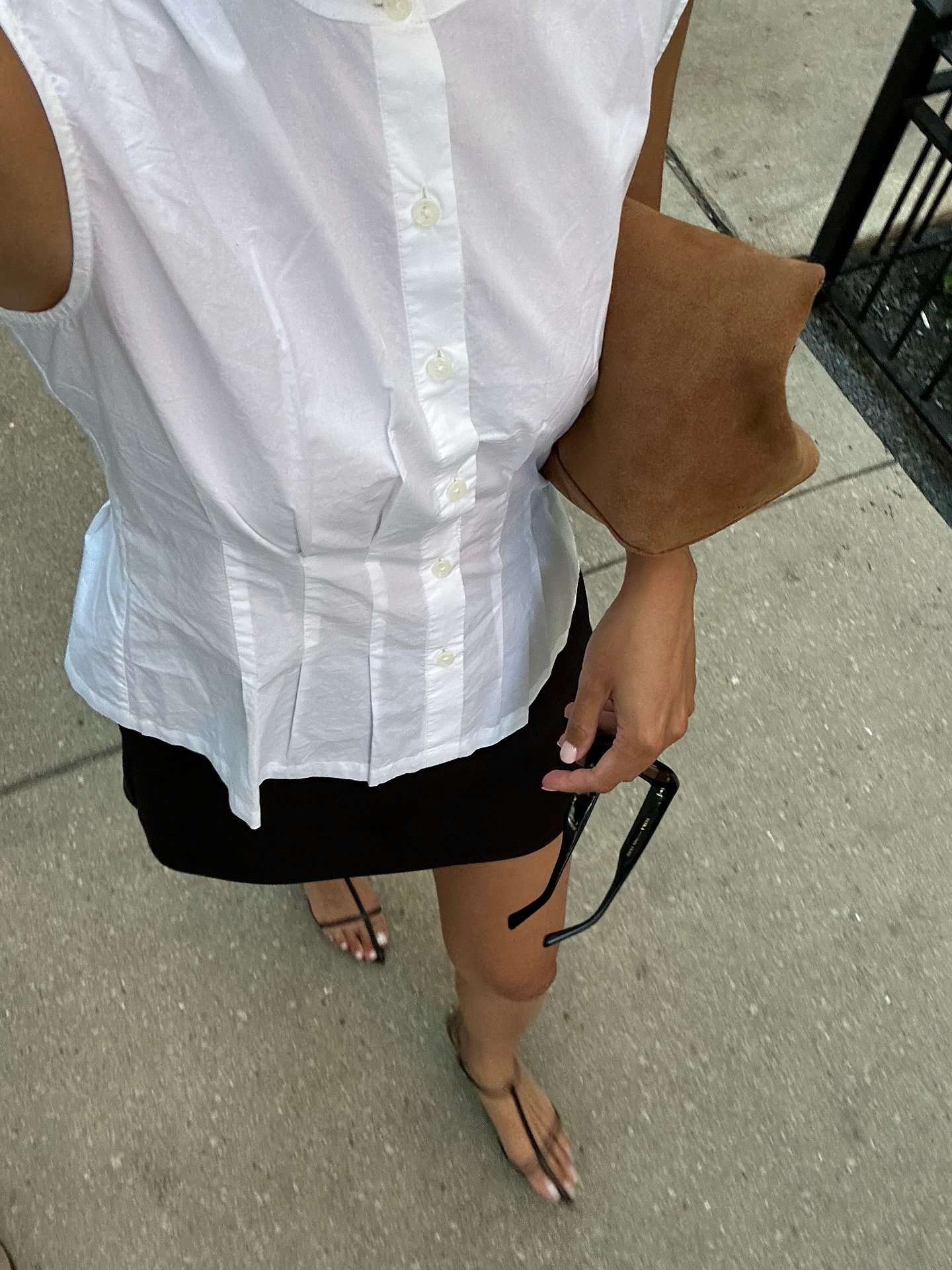 O look com saia preta curta é composto por uma blusa branca de botão, que traz elegância e frescor. A saia, justa e moderna, destaca as pernas, ideal para dias quentes. Representa looks com saia preta curta.