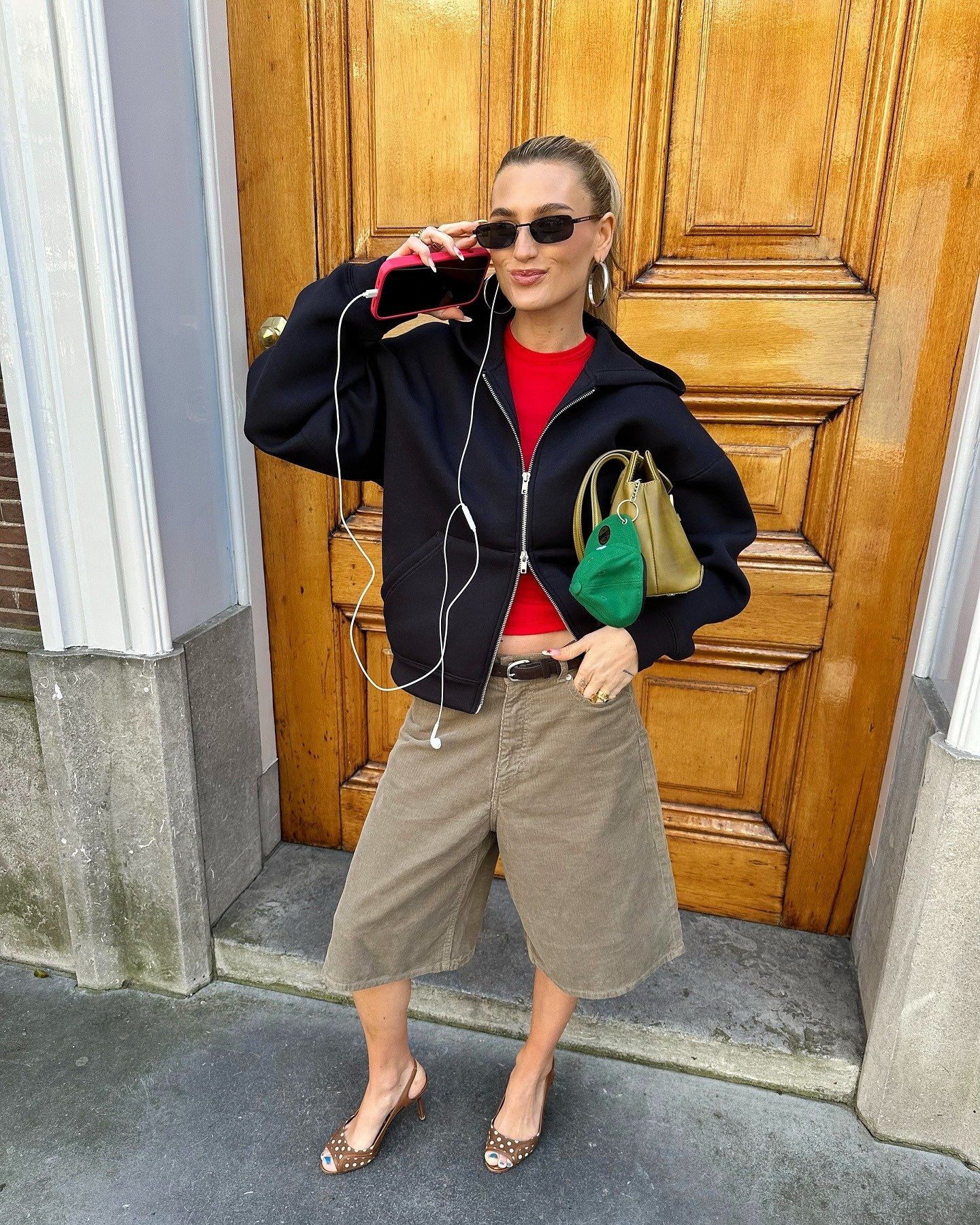 A imagem exibe uma mulher estilosa usando um conjunto moderno que combina conforto e elegância. O destaque vai para o sapato peep-toe, com design sofisticado e detalhes em poá, que complementa seu look casual.