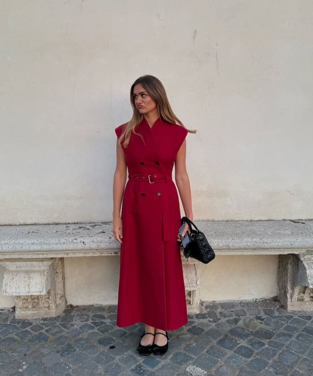 O look apresenta um vestido vermelho vibrante, com design elegante e moderno, ideal para ocasiões natalinas. O vestido, com mangas curtas e cintura marcada por um cinto, destaca a silhueta.