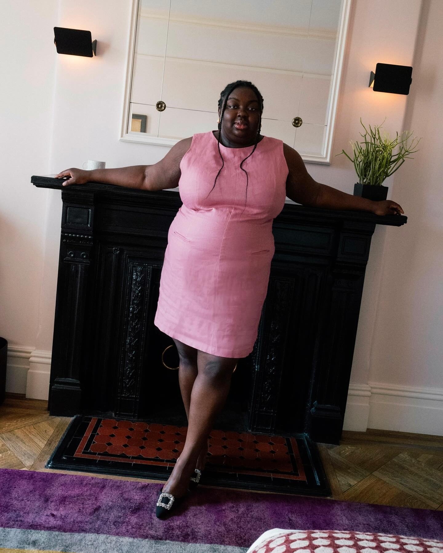 Modelo posa confiante com vestido rosa de modelagem reta em linho, combinando looks estilosos e fáceis com toque sofisticado.