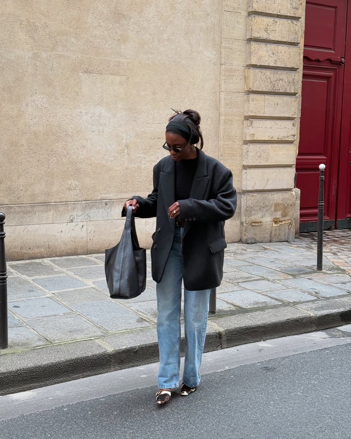 Ideias de looks femininos casual composto por blazer oversized preto, jeans claros de corte reto e bolsa de couro