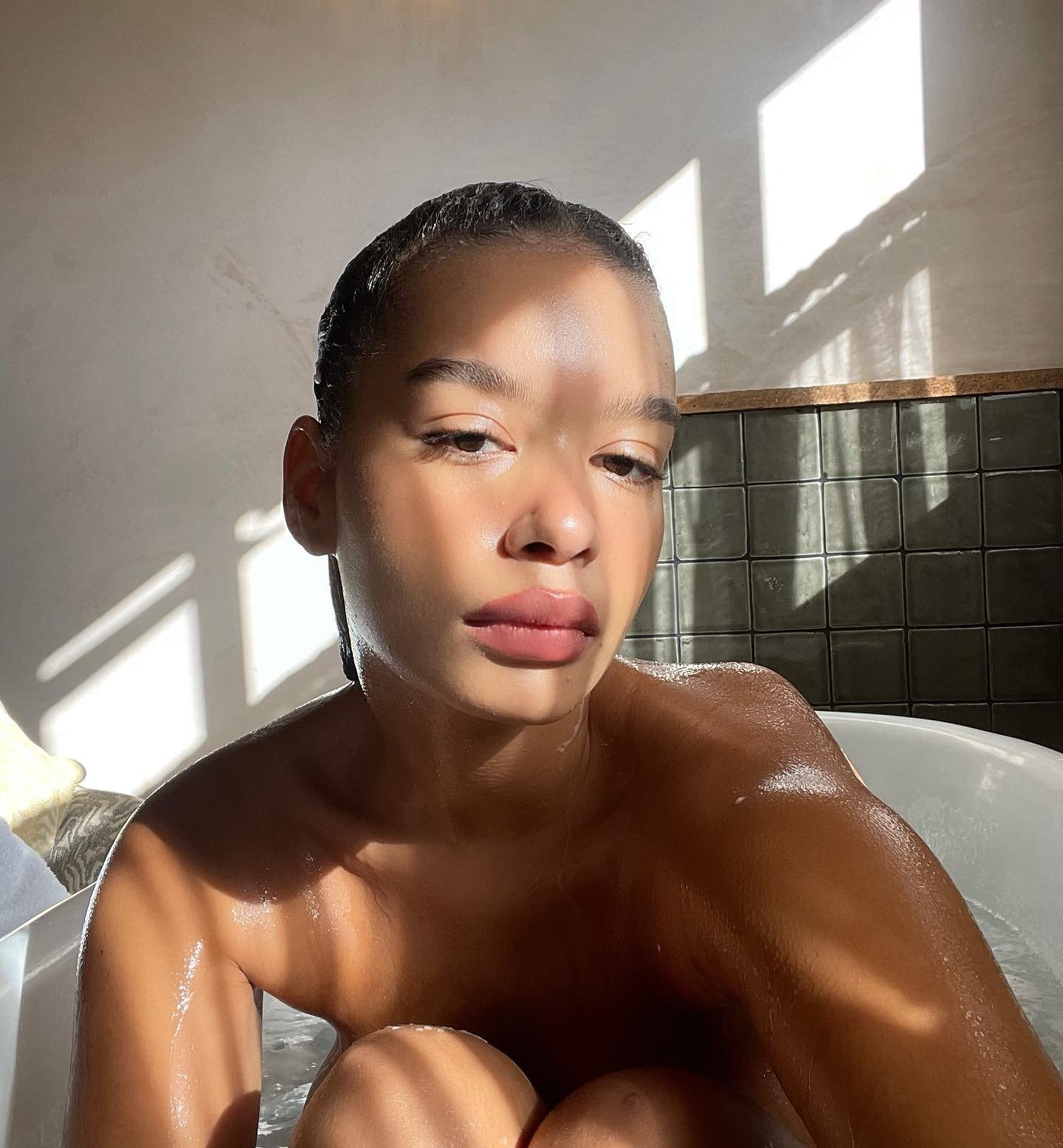 Modelo com pele hidratada e luminosa em banho de luz natural, transmitindo cuidado e a importância do que é bom para pele