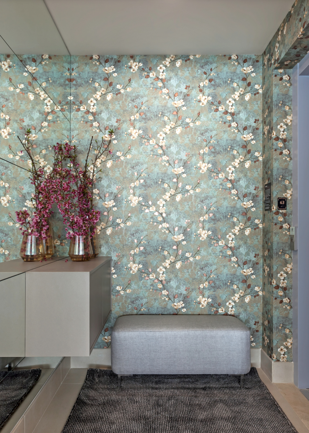 Papéis de parede com padrão floral delicado em tons de azul e bege criam ambiente acolhedor e elegante, complementado por