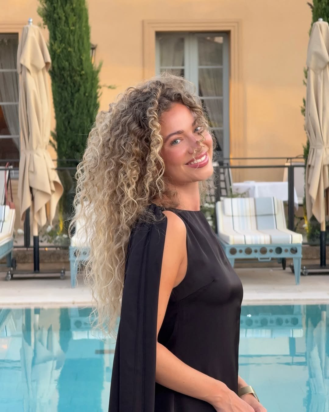 Modelo posa sorrindo com vestido preto de tecido fluido, com retrospectiva 2025 dos produtos de beleza virais do TikTok