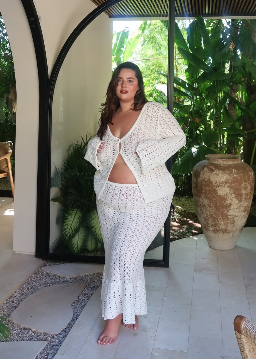 Mulher em pé em ambiente aberto usando conjuntinho representando roupas brancas bonitas para o Ano Novo.