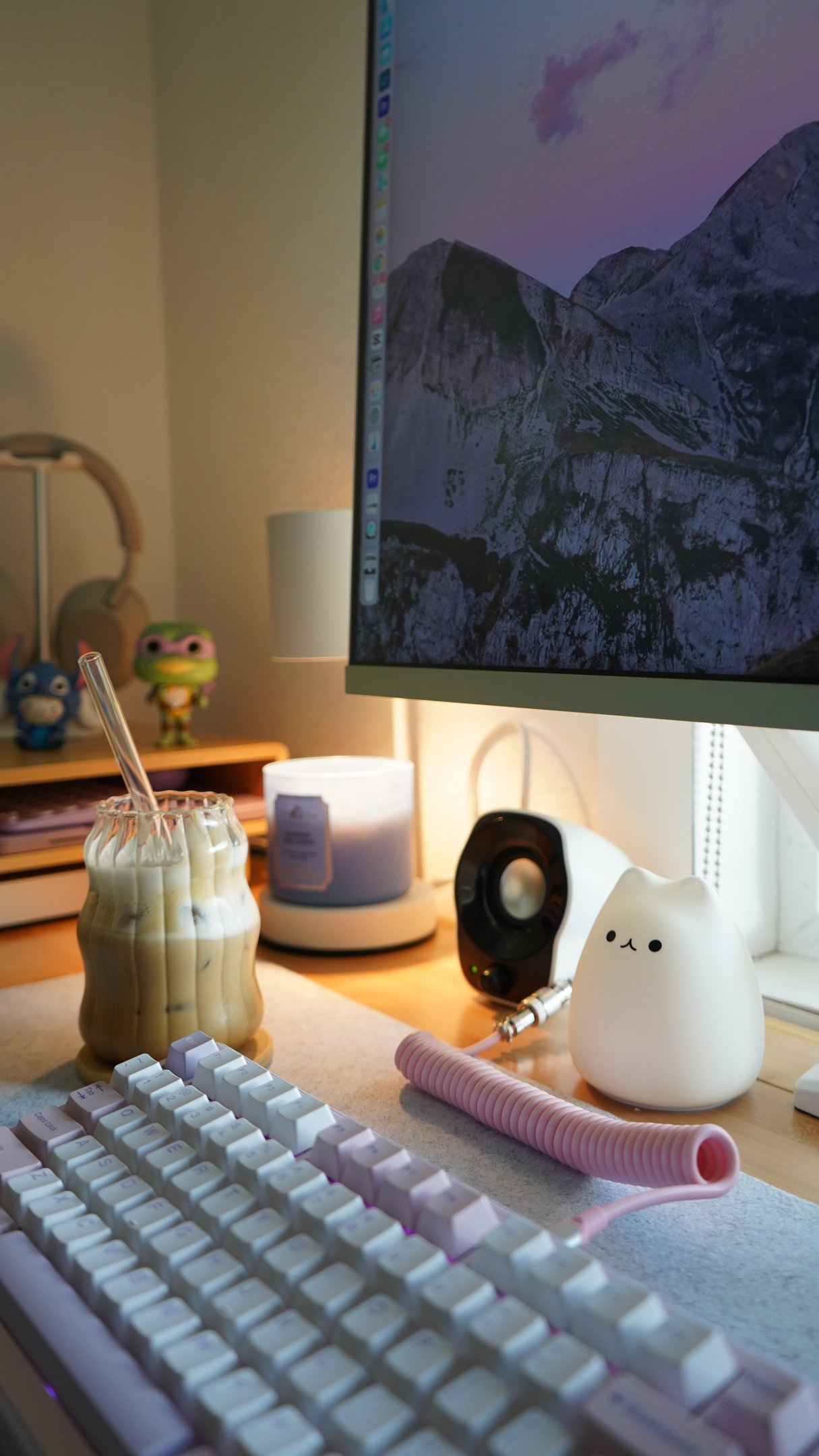 Quarto de adolescente com decoração aconchegante, teclado branco, copo com bebida gelada, luminária fofa e figuras