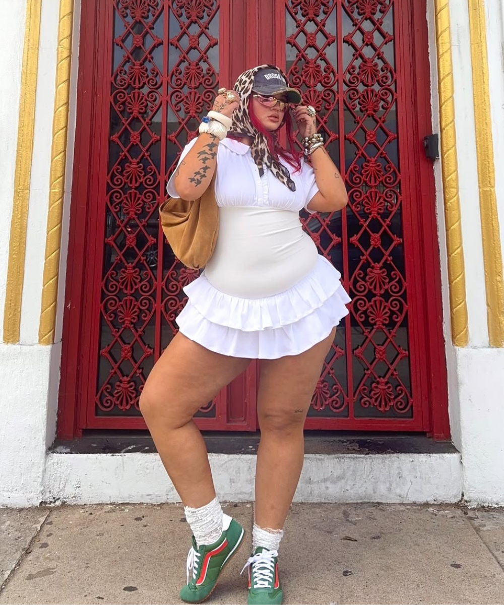 Modelo posa confiante com vestido branco de babados, tênis tendência de 2026 verde com detalhes laranja, e acessórios