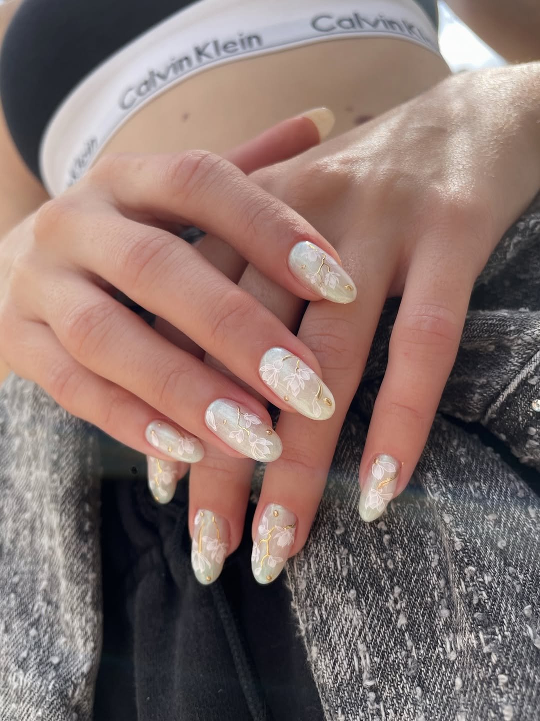 Unhas para o natal e ano novo em tom perolado com detalhes florais brancos e dourados.