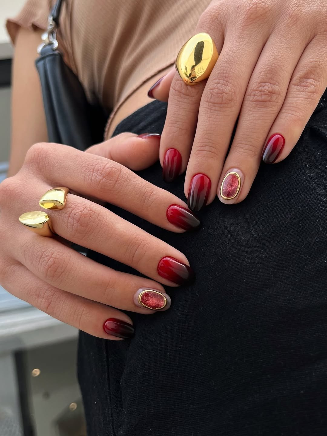 Unhas para o natal e ano novo em degradê vermelho e preto com detalhes dourados.