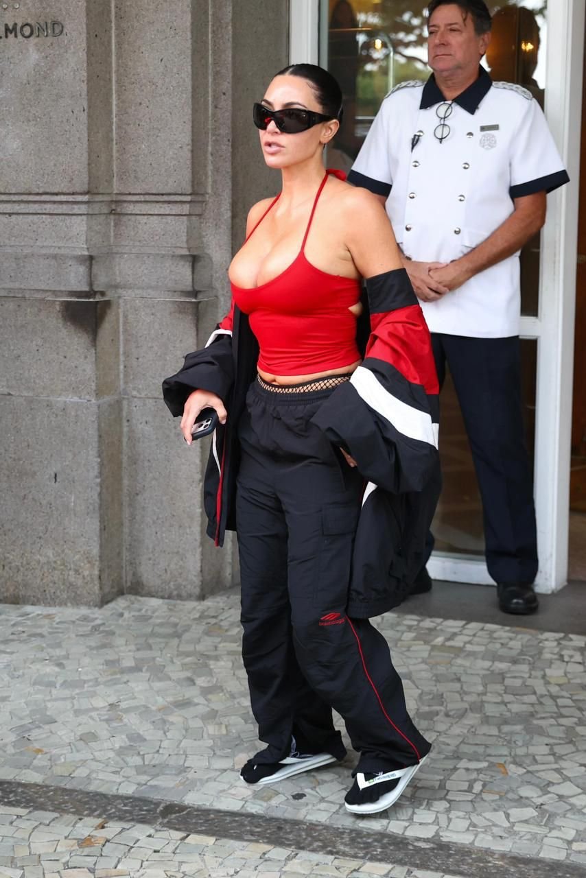 kim kardashian usando havaianas  em um look urbano e moderno, com um top vermelho e calças largas pretas.