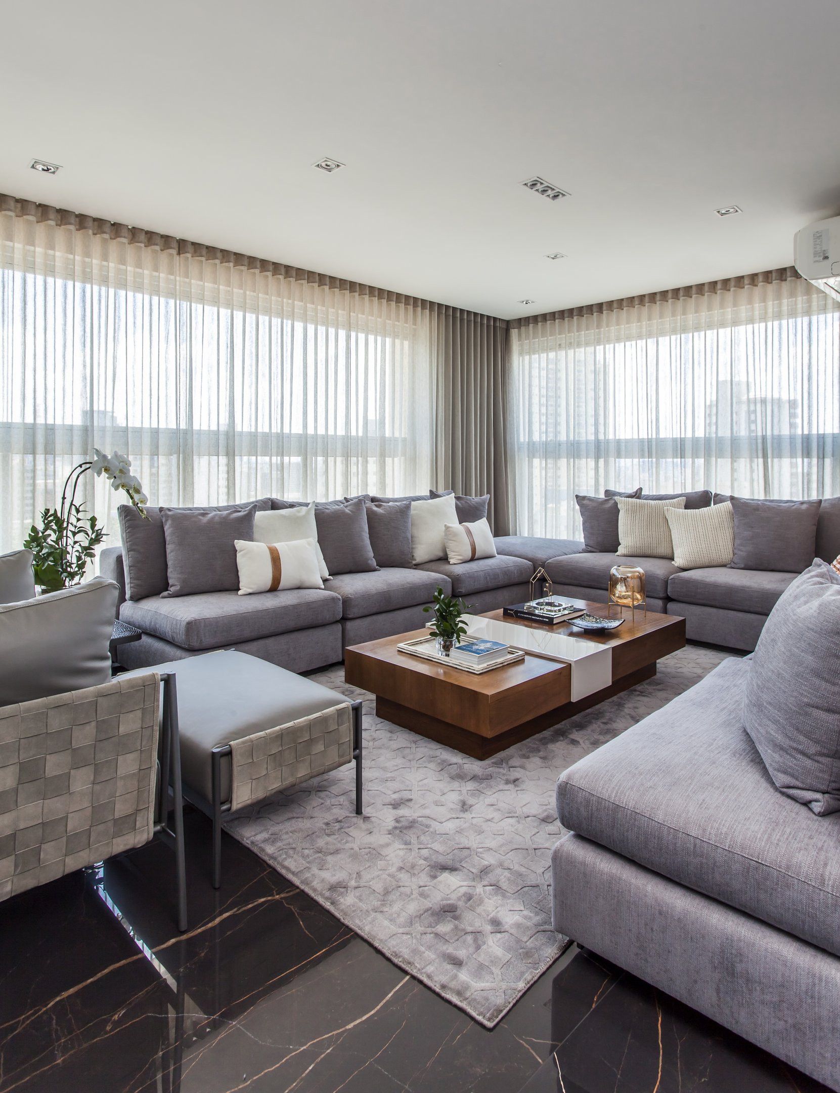 Sala de Natal em casa com sofá modular cinza de tecido macio, almofadas claras, mesa de centro em madeira