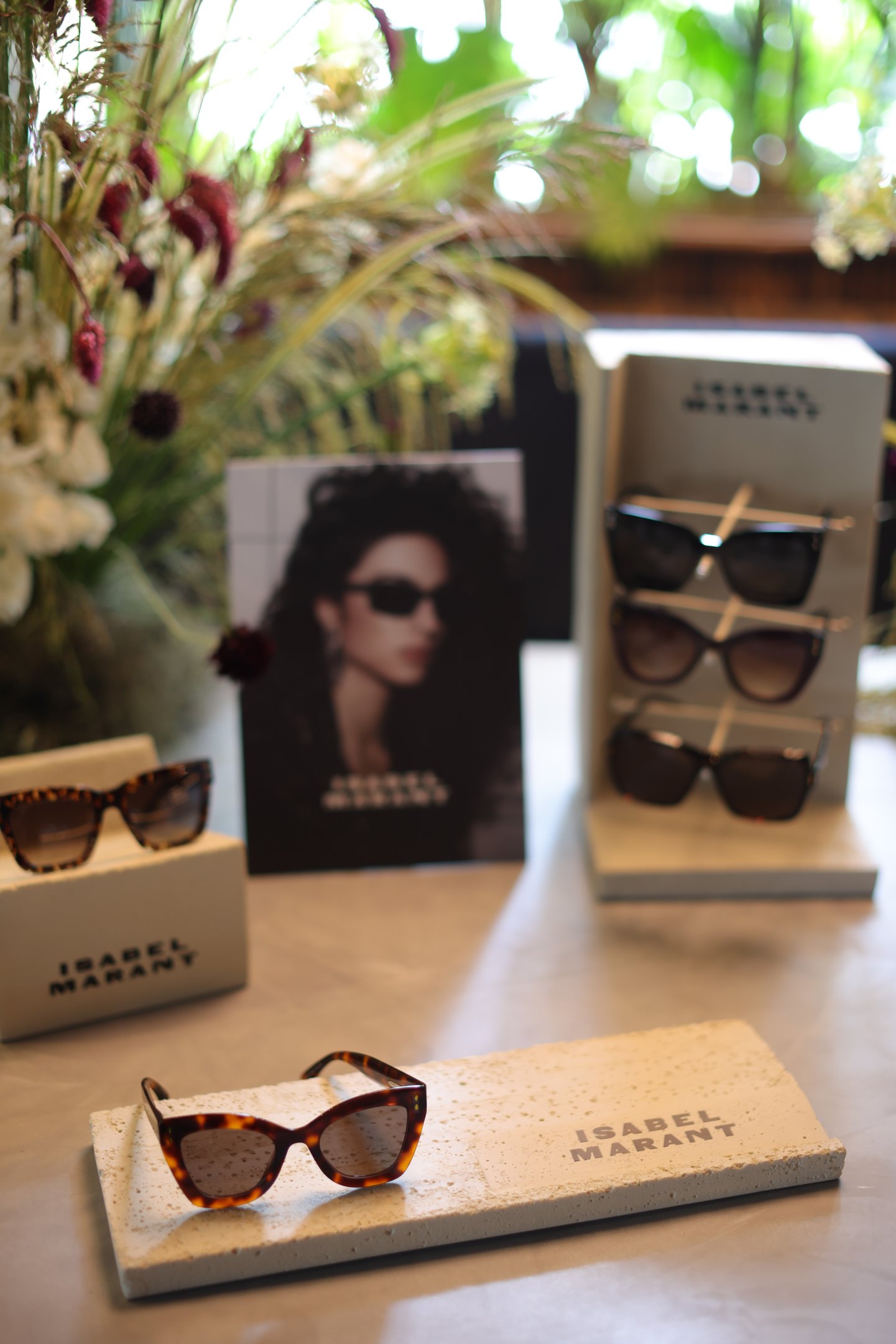 Óculos de sol Isabel Marant com armação tartaruga e design oversized, exibidos em base texturizada clara